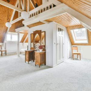 Cozy furnished attic with a high wooden ceiling