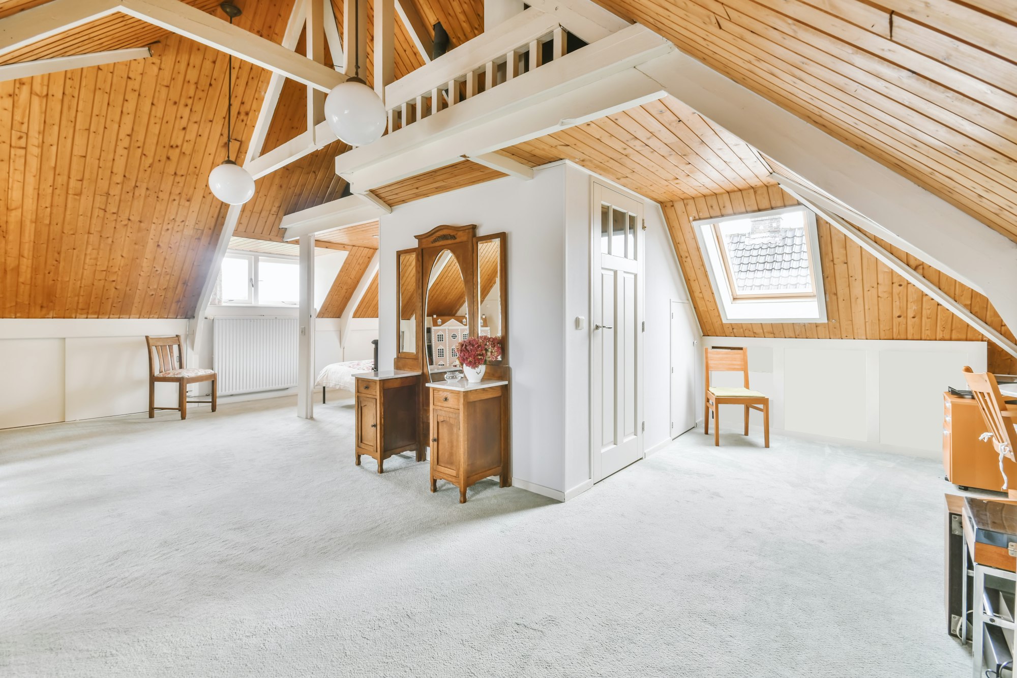 Cozy furnished attic with a high wooden ceiling